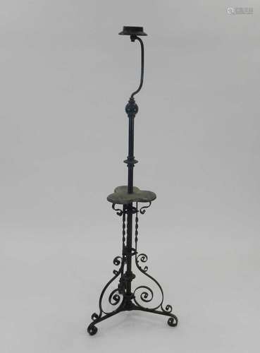 An Edwardian wrought iron lamp standard, the knopped stem with central trefoil wood tier, raised