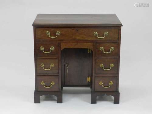 A George III style mahogany kneehole desk, the moulded top above a frieze drawer and six further