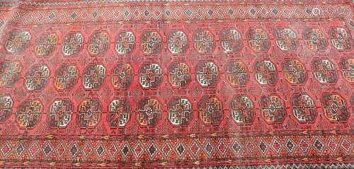 A Persian rug, first half 20th Century, with multiple geometric medallions on a red ground within