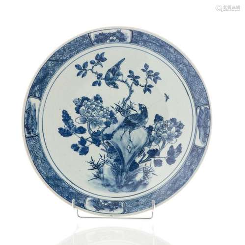 Plat en porcelaine émaillée bleu blanc à décor d'un oiseau branché. Chine (Diam : 40 cm)