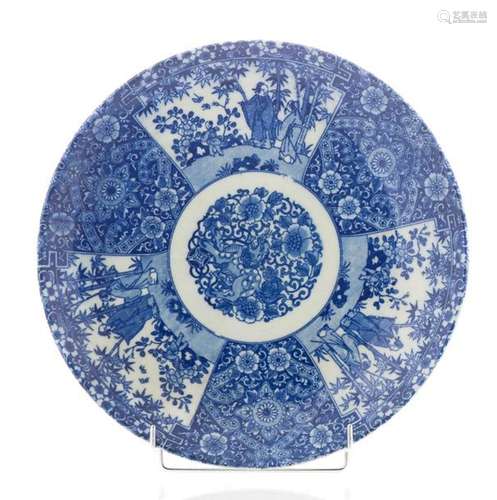 Plat en porcelaine émaillée bleu blanc, les ailes à décor de personnages dans des cartouches, le centre à décor d'un lion bouddhique. Chine (diam : 37 cm)