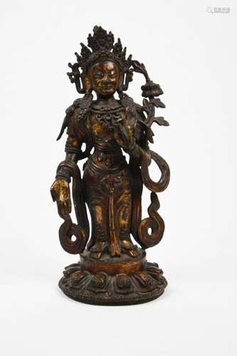 Sujet en bronze laqué or, représentant le Bodhisattva Padmapani debout sur un lotus, la main droite abaissé en varada-mudra, geste du don, la gauche levée en vitarka-mudra, geste de l'argumentation, tenant une tige de lotus remontant le long du bras jusqu'à la fleur épanouie à hauteur de l'épaule. La divinité, entourée de son écharpe volante, est richement parée de bijoux et couronnée d'une haute tiare. Tibet, XVIIe siècle.  (Usure de la laque) H. 25,5 cm Provenance : Collection du Baron de M., administrateur des Douanes en Chine dans les années 1920. Puis par descendance.Expert : Cabinet Ansas et Papillon Pour participer aux enchères du lot 78 une caution sera demandée.To bid on this lot 78, a deposit will be required.Pas d'enchères en LIVE / No bid in Live