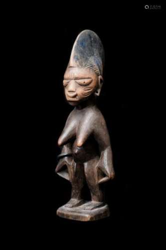 Statuette Ere ibeji fémininYORUBA - Nigéria, région d'Abeokuta  style d'Egba (H : 23,5 cm)Bois, laiton, trace de bleu de lessive, ocre rougeLes statuettes d'ibeji sont habituellement sculptées par paires et représentent des jumeaux dont l'âme est indivisible. La venue des jumeaux était anciennement mal acceptés, leur naissance marquait une anormalité. Si un des jumeaux meurt pendant la petite enfance, une statuette ibeji était sculptée en son honneur.Expert : M. Jean-Pierre Lacoste