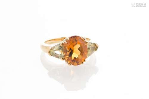 Bague en or jaune 750 millièmes sertie d'une citrine taille ovale d'environ 3,5 ct, épaulée de deux saphirs vert taille troïda TDD 53(Poids brut : 6,7 g)