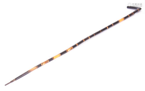 A 19TH CENTURY SECTIONAL HORN WALKING STICK of tapered form with angular handle 93cms overall