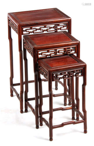 A 20TH CENTURY NEST OF THREE CHINESE HARDWOOD OCCASIONAL TABLES having shaped legs joined by pierced