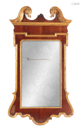 A GEORGE III PARCEL GILT AND MAHOGANY HANGING MIRROR with swan-neck pediment above a mirror frame