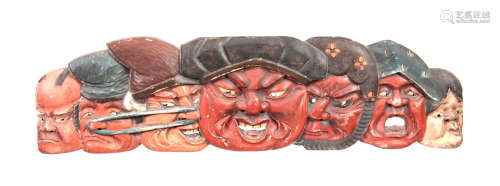 A 19th CENTURY JAPANESE CARVED WOOD AND LACQUER WALL PANEL depicting seven faces of Japanese