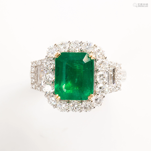 An emerald, diamond and eighteen karat white gold ring