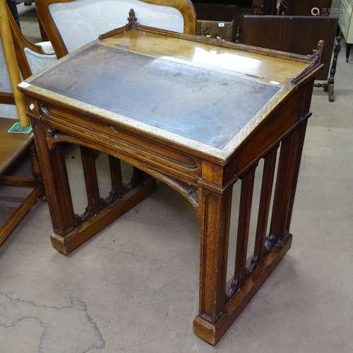 A Victorian oak clerk's writing desk in Pugin style, with tooled leather rising top, W76cm, H84cm,