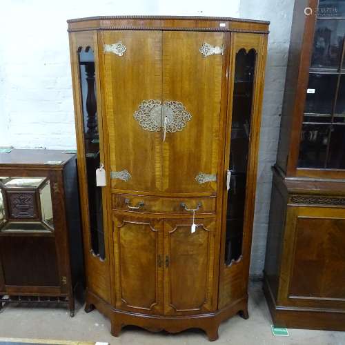 A good quality cross-banded mahogany cocktail cabinet of canted form, with 4 panelled doors