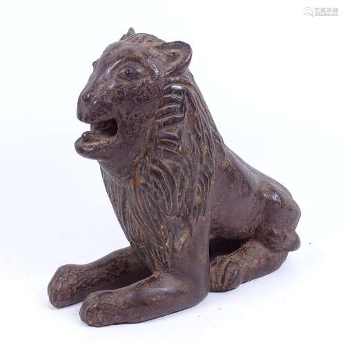 A large unusual carved and stained wood recumbent lion, height 28cm