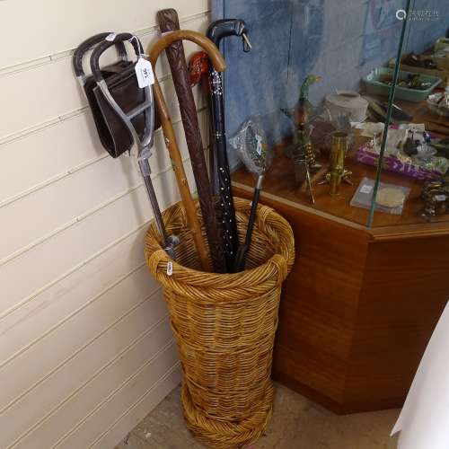 A wickerwork stick stand, containing various sticks, including African examples and shooting stick