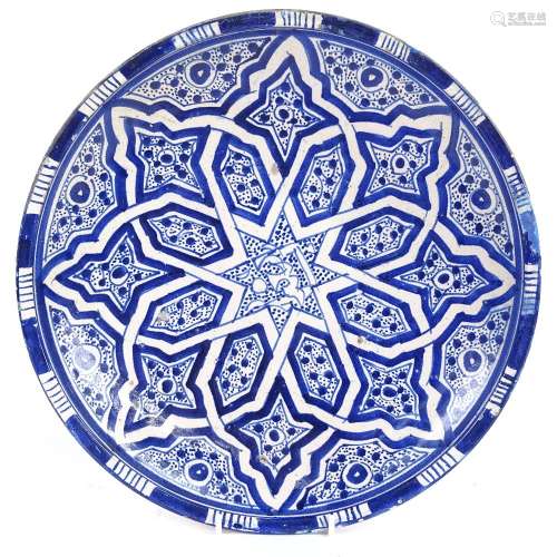 A large Persian Middle Eastern blue and white pottery charger, with Islamic decoration and Arabic