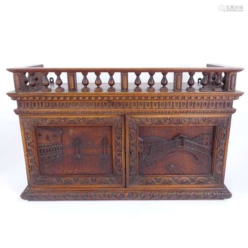 A Grand Tour style carved mahogany wall-hanging cabinet, with Venetian scene carved panel doors,