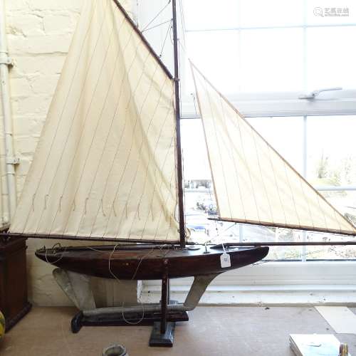 A large 19th century wooden hulled model pond yacht, with masts and rigging, hull length 82cm, on