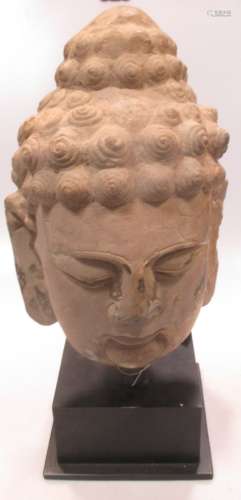 A cast concrete and painted head of Buddha, 34cm high
