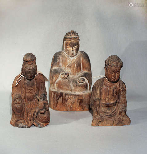 Three Chinese carved wood seated figures, two of a Buddha, the other of Guanyin with child,