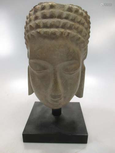 An Indian carved and painted stone figure of a deity, 20th century, and a Thai carved stone head
