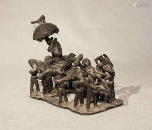 A West African bronze small group, of a chief being carried on a canopied palanquin by eleven men,