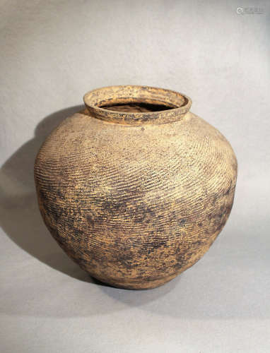 A Chinese grey-ware pottery large compressed jar with grooved decoration throughout, perhaps Warring