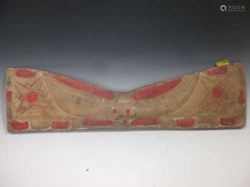 A North American Indian carved and painted pine rest panel, carved in low relief with a stylized