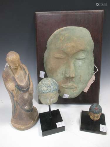 A bronze mask in archaic style, possibly Korean, on wooden plaque back: two decorative Buddha