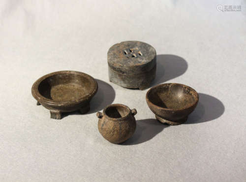 A group of four Chinese green and grey stone small vessels, archaic type, including a five footed