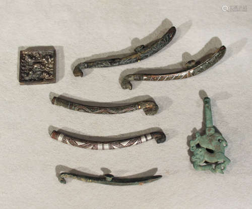 Six Chinese bronze and inlaid belt hooks in Han/Warring States style, and a square bronze 