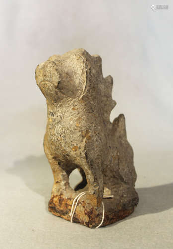 A Chinese grey stone seated Fo dog, with serrated crest in archaic style, 17cm high