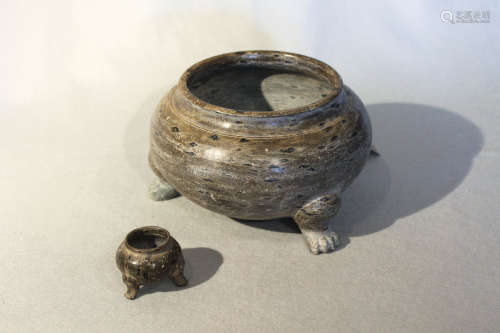 Two Chinese green puddingstone plain compressed ovoid tripod bowls, perhaps Tang Dynasty, the