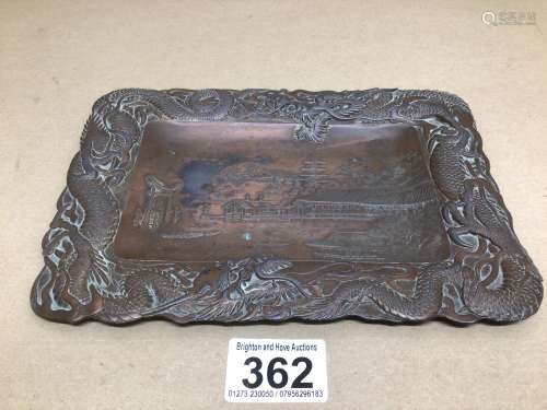 AN ANTIQUE JAPANESE BRONZED TRAY WITH A RIVER SCENE AND CHASING DRAGONS AROUND THE BORDERS