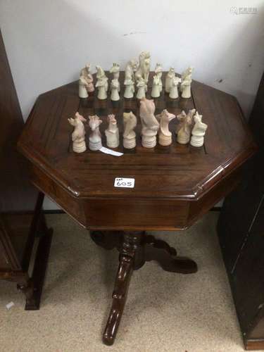 A VINTAGE WOODEN MAHOGANY GAMES TABLE WITH COMPARTMENT FOR CHESS PIECES WHICH ARE MADE FROM