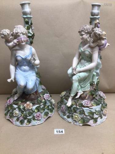 TWO 19TH CENTURY LARGE PORCELAIN CANDLESTICKS FIGURES SEATED WITH CHERUBS AND FLOWERS, CONTINENTAL