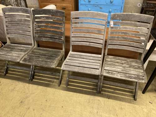 A set of four weathered teak folding garden chairs