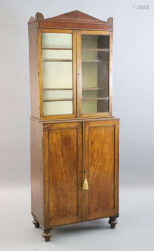 A Regency mahogany collector's cabinet, with architectural cornice and two glazed doors over two