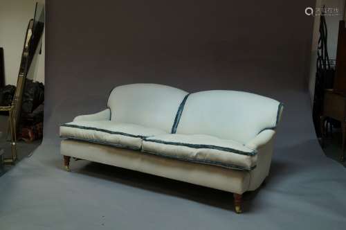 A three seat sofa, possibly George Smith, raised on brass casters and turned wood legs, George Smith