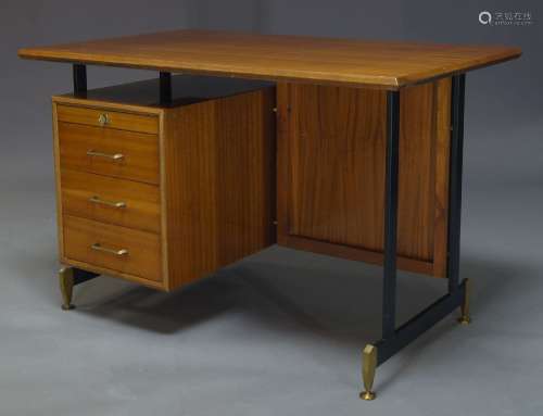An Italian teak desk, c1960, the rectangular top above a bank of three drawers, raised on black
