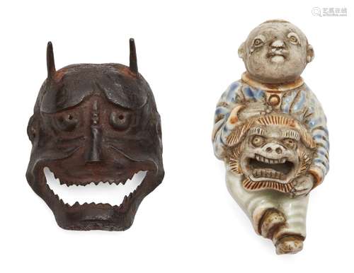 A Japanese porcelain netsuke, 19th century, modelled as a Chinese boy holding a lion dance mask,