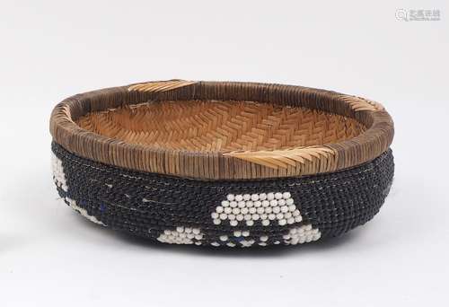 A Zambian beaded basket, 20th century, of circular form, the woven body with beaded cover, with