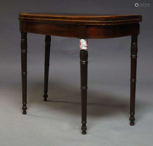 A George III mahogany and crossbanded card table, the fold over top enclosing green baize lined