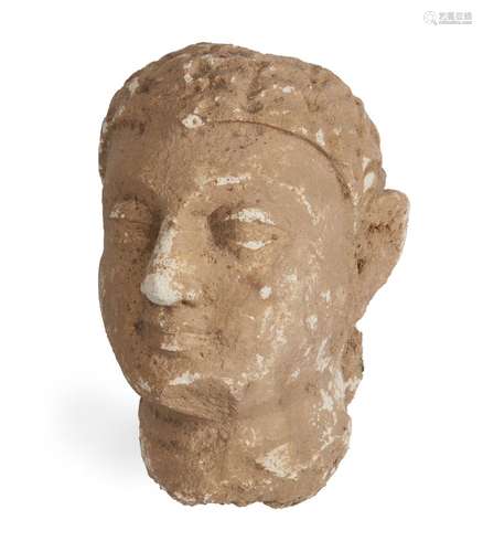 A Gandhara stucco head of a Buddha, Afghanistan, 3-4th century, with bow-shaped mouth and heavy-