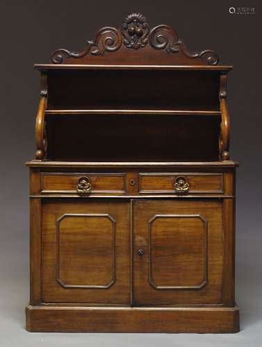 A Victorian mahogany credenza, the raised back with shaped and carved top, above two shelves, on