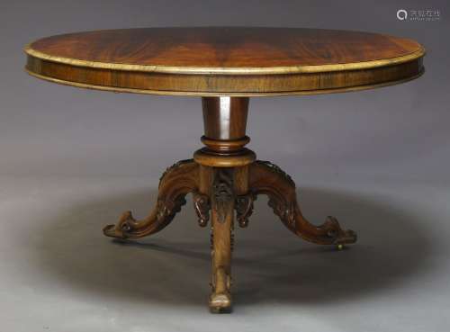A Victorian rosewood tilt top breakfast table, the circular top on tapered column support to foliate