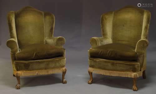 A pair of George III style wing back arm chairs, early to mid 20th Century, with curved wings and