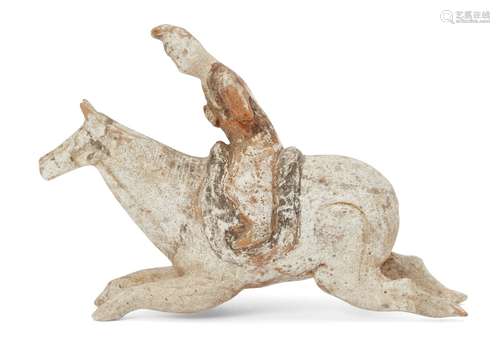 A Chinese miniature pottery figure of a polo player, Tang dynasty, in full gallop, painted in