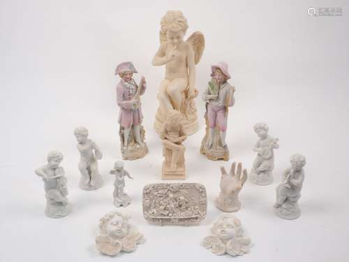 A collection of cherubic figurines, 20th century, to include a larger example of Cupid seated on a