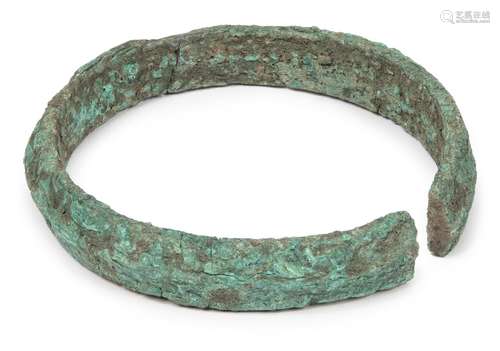 A Chinese bronze neck ring, Neolithic period, with central ridge, heavily encrusted, 13cm diameter