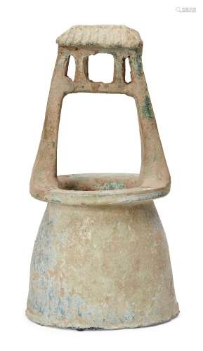 A Chinese pottery model of a well, Han dynasty, with ridged sloping roof, covered in a green