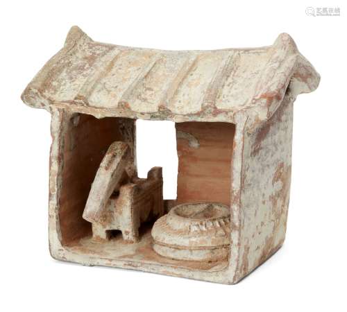 A Chinese pottery model of a mill, Han dynasty, with ridged sloping roof above quern stone and